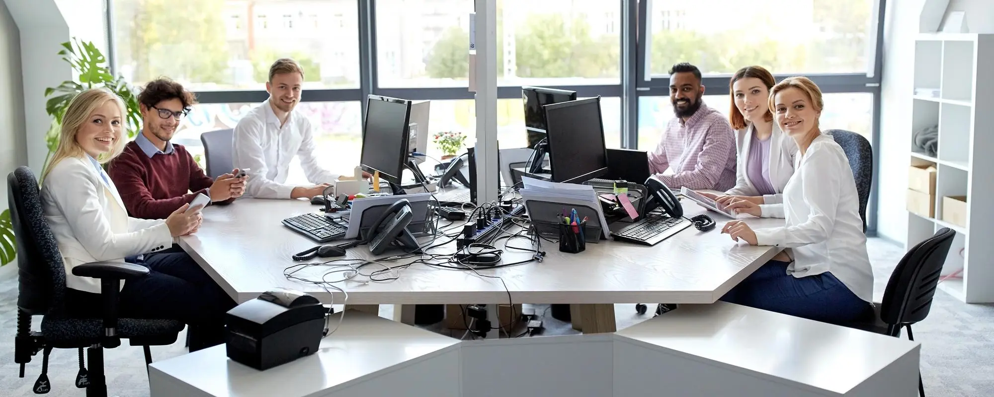 Team arbeitet gemeinsam mit CRM‑Software in moderner Büroumgebung